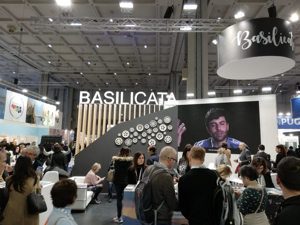 Stand Basilicata in fiera con schermi e visitatori