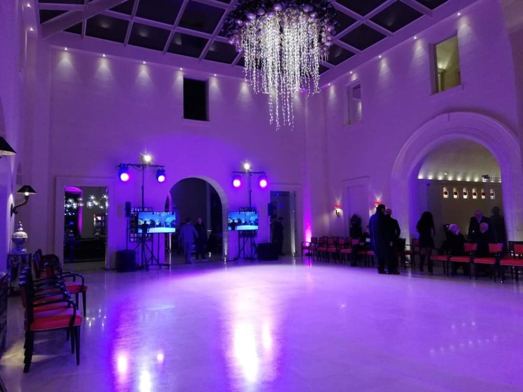 Sala da ballo con illuminazione colorata e lampadario di cristallo